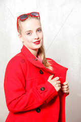 Berlin  Deutschland  junges Maedchen posiert in rotem Mantel