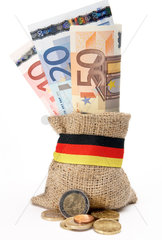 Berlin  Deutschland  Muenzen vor einem kleinen Jutebeutel mit EURO-Geldscheinen