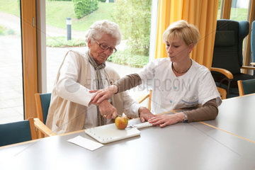 Essen  Deutschland  eine Altenpflegerin hilft einer Schlaganfallpatientin bei Alltagsuebungen