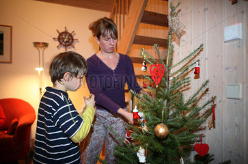 Wendisch Rietz  Deutschland  Mutter und Sohn schmuecken einen Weihnachtsbaum