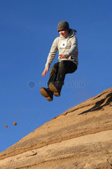 Schependorf  Deutschland  ein Junge springt von einem Sandhuegel
