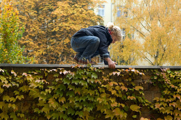 Berlin  Deutschland  Kind klettern auf einer Mauer