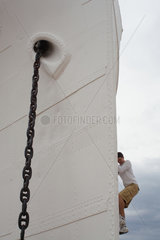 Le Barcares  Frankreich  junger Mann klettert an der Ankerkette des Schiffes Lydia