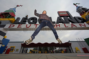Guenzburg  Deutschland  Junge macht vor dem Eingang zum Legoland Deutschland einen Luftsprung