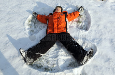 Potsdam  Deutschland  Junge macht einen Schneeengel