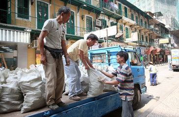 Macau  China  Maenner laden Saecke von einem LKW