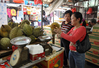 Macau  China  Frau prueft Durian-Fruechte an einem Marktstand
