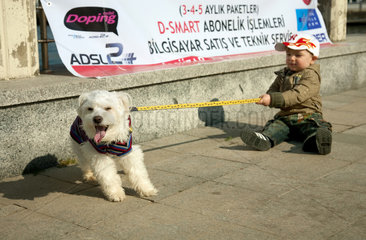 Heybeliada  Istanbul  Tuerkei  Junge versucht seinen Hund an der Leine zu ziehen