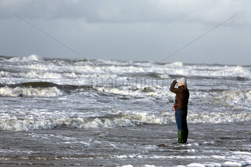 Blavand  Daenemark  eine Frau schaut am Strand in die Ferne