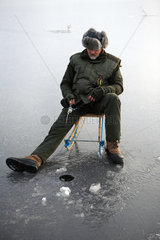 Belloe  Schweden  Mann beim Eisangeln auf dem See Stora Bellen