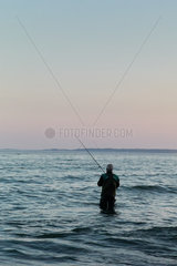 Ostseeinsel Ruegen  Mecklenburg-Vorpommern  Deutschland - Angler fischt im Wasser stehend