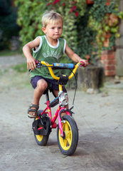 Prangendorf  Deutschland  Junge faehrt Fahrrad