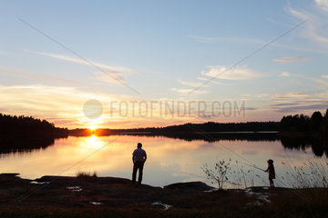 Silvkoparen  Schweden  ein Mann und ein Maedchen am Ufer eines Sees