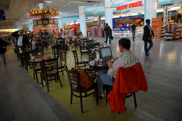 Istanbul  Tuerkei  ein Mann mit Laptop in einem Cafe im Atatuerk International Airport