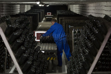 Republik Moldau  Weinkellerei Cricova SA  Arbeiter sortiert abgefuellte Flaschen von Schaumweinen fuer die Lagerung