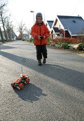 Wendisch Rietz  Deutschland  Kind spielt mit einem Spielzeugauto auf der Strasse