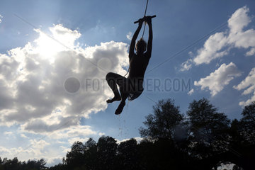 Briescht  Deutschland  Silhouette  Junge schwingt sich an einem Seil durch die Luft