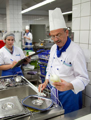 Essen  Deutschland  Koch prueft das Essen in einem Gastronormbehaelter