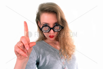 Frau mit dicker Brille und Fingerzeig