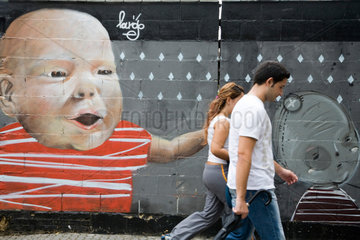 Sevilla  Spanien  Passanten laufen an einer Graffiti-Wand vorbei