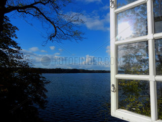 Goehren-Lebbin  Deutschland  Blick aus einem geoeffneten Fenster auf einen See