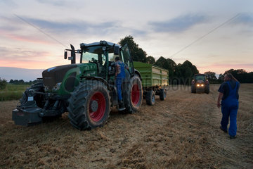 Penzlin  Deutschland  Landwirte bei der Ernte am spaeten Abend