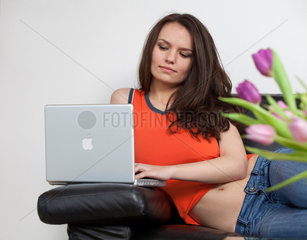 Bonn  Deutschland  Frau mit Laptop auf dem Sofa