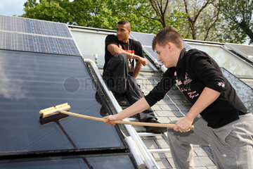 Berlin  Deutschland  Auszubildende putzt einen Solarkollektor