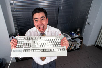 Mann aergert sich ueber Tastatur