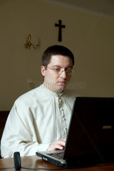 Krakau  Polen  Priester an seinem Laptop