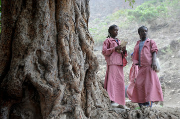 Zala Zembaba  Aethiopien  zwei Maedchen stehen an einem alten grossen Baum