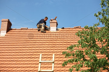 Sosnowka  Polen  ein Dachdecker verkleidet den Schorstein mit Kupferblech