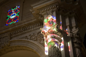 Sevilla  Spanien  Kirchenfenster reflektiert farbig auf einer Saeule