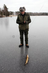 Belloe  Schweden  Mann hat beim Eisangeln einen Hecht gefangen