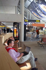 Tallinn  Estland  ein Mann sitzt mit seinem Notebook am Flughafen Tallinn