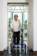 Riedlingen  Deutschland  Seniorin mit Gehhilfe verlaesst einen Fahrstuhl