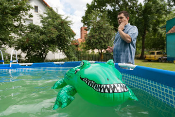 Breslau  Polen  ein Gummikrokodil im aufblasbaren Pool im Garten