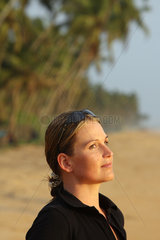 Wadduwa  Sri Lanka  Frauenportraet mit Sonnenbrille am Strand mit Palmen