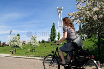 Berlin  Deutschland  Radfahrerin faehrt durch den Mauerpark in Prenzlauer Berg