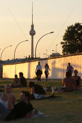 Berlin  Deutschland  junge Menschen beim Sonnenuntergang an der East-Side-Gallery