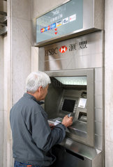 Macau  China  Mann an einem Geldautomaten der HSBC Bank