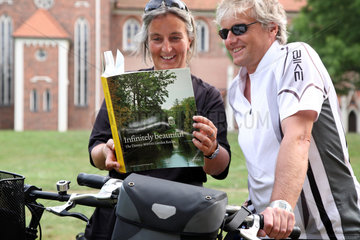 Woerlitz  Deutschland  Touristen lesen ein Buch ueber den Woerlitzer Garten
