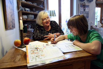 Berlin  Deutschland  Oma hilft ihrem Enkel bei den Hausaufgaben fuer die Schule