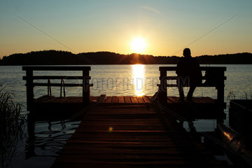 Wigry  Polen  ein Mann geniesst den Sonnenuntergang ueber dem Wigry-See