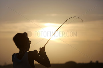 Cape Canaveral  USA  Junge angelt bei Sonnenuntergang