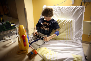 Berlin  Deutschland  Junge sitzt in einem Krankenhausbett