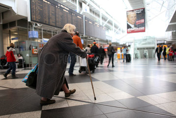 Muenchen  Deutschland  eine alte Frau laeuft im Flughafen Franz-Josef-Strauss