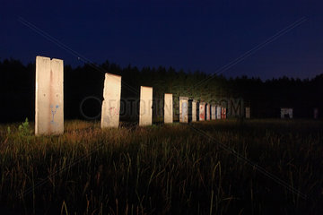 Sosnowka  Polen  aufgestellte Stuecke der Berliner Mauer in der Nacht