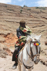 Mangudo  Aethiopien  ein Bauer reitet mit seinem Pferd ueber die Berge