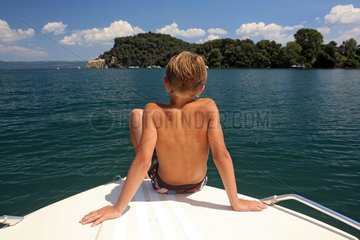 Capodimonte  Italien  Junge sonnt sich am Bug eines Motorbootes